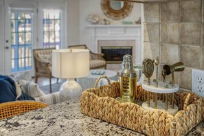 A kitchen counter with a woven basket containing a bottle and a set of kitchen utensils.