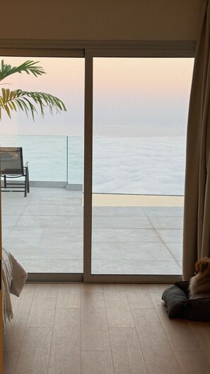 Ein Zimmer mit Meerblick durch eine Schiebetür.
