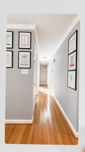 A hallway with framed rules on the walls and a wooden floor. - Soothing 1-bedroom house with Free Parking in Fort Washington (Fort Washington)