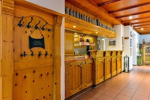 A wooden interior with a bar area, a coat rack, and a plaque on the wall. - Nagerl Landhotel (Marzling)