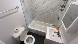 Ein Badezimmer mit Toilette, Waschbecken und Badewanne.