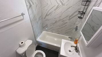 Een badkamer met toilet, wastafel en bad.