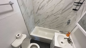 Ein Badezimmer mit Toilette, Waschbecken und Badewanne.