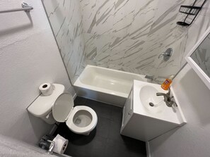 Ein Badezimmer mit Toilette, Waschbecken und Badewanne.