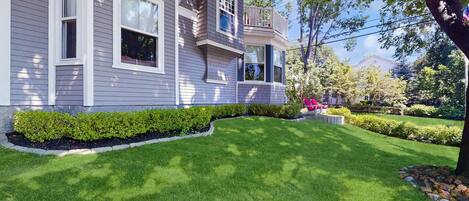 A residential house with a well-maintained lawn and a small garden area.