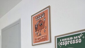 Uma cozinha com geladeira, forno e duas quadros na parede.