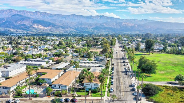 A residential area with houses, a road, and mountains in the background.