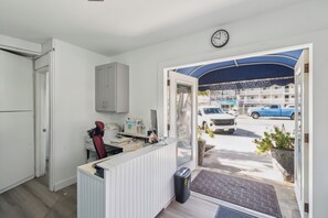 Un área de recepción con un mostrador, computadora y un reloj en la pared.