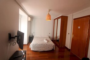 A bedroom with a bed, a desk, a chair, a hanging lamp, and a wardrobe. - Apartamentos Good Stay Atocha (Madrid)