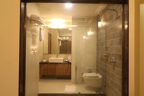A bathroom with a toilet, sink, and mirror. - Vits Kamats Resort (Silvassa)