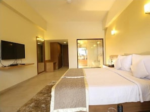 Hotelkamer met een bed, een televisie aan de muur, een spiegel en een badkamer door een open deur zichtbaar.