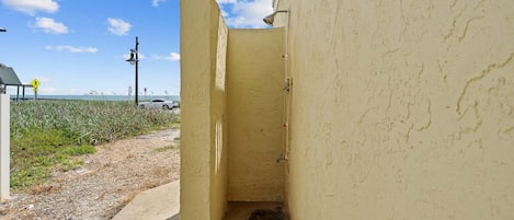A narrow alleyway with a yellow wall and a small opening.