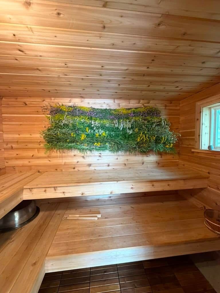 Un intérieur en bois agrémenté d’un jardin vertical intégré, d’un banc et d’une fenêtre.