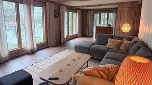 Ett mysigt vardagsrum med en soffa, ett soffbord och en lampa.