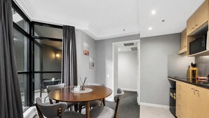 A modern kitchen with a microwave, wooden cabinets, and a dining area with a round table and chairs.