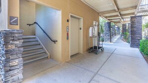 A covered outdoor area with a staircase, an elevator, and a cart. - Desert Rendezvous at Estancia Resort (Saint George)