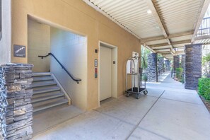 Ein überdachter Außenbereich mit Treppe, Aufzug und Einkaufswagen.