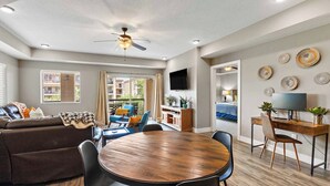 A modern living room with a sofa, dining table, chairs, and a ceiling fan. - Desert Rendezvous at Estancia Resort (Saint George)