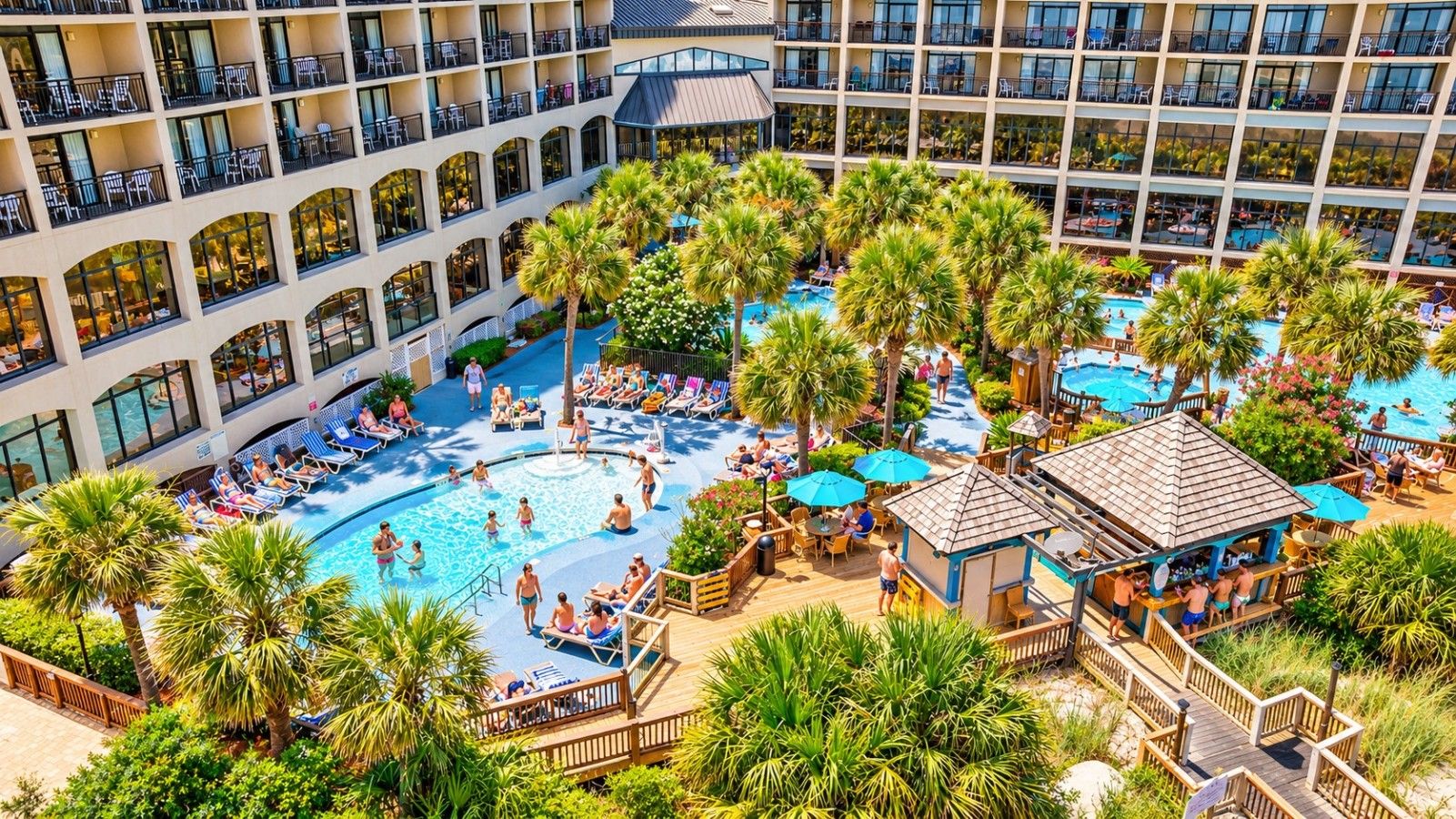A hotel with a large outdoor pool surrounded by palm trees and lounge chairs.
