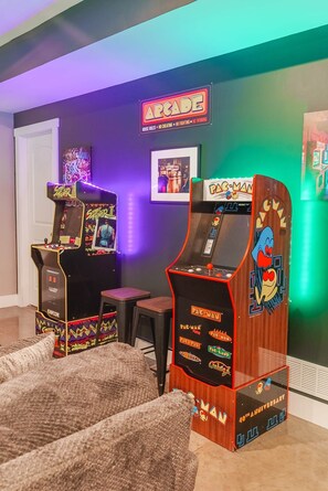 A room with arcade games, including Street Fighter II and Pac-Man, and a neon sign that reads 'ARCADE'. - Scout's Retreat (Green Township)
