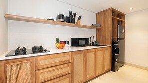 Eine moderne Küche mit Gaskochfeld, Mikrowelle, Spüle und Kühlschrank.