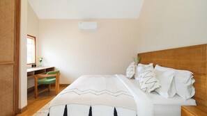 Ein Schlafzimmer mit einem Bett, einem Schreibtisch, einem Stuhl und einem Fenster.