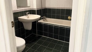 Un bagno con un lavandino bianco, un water e una vasca da bagno.