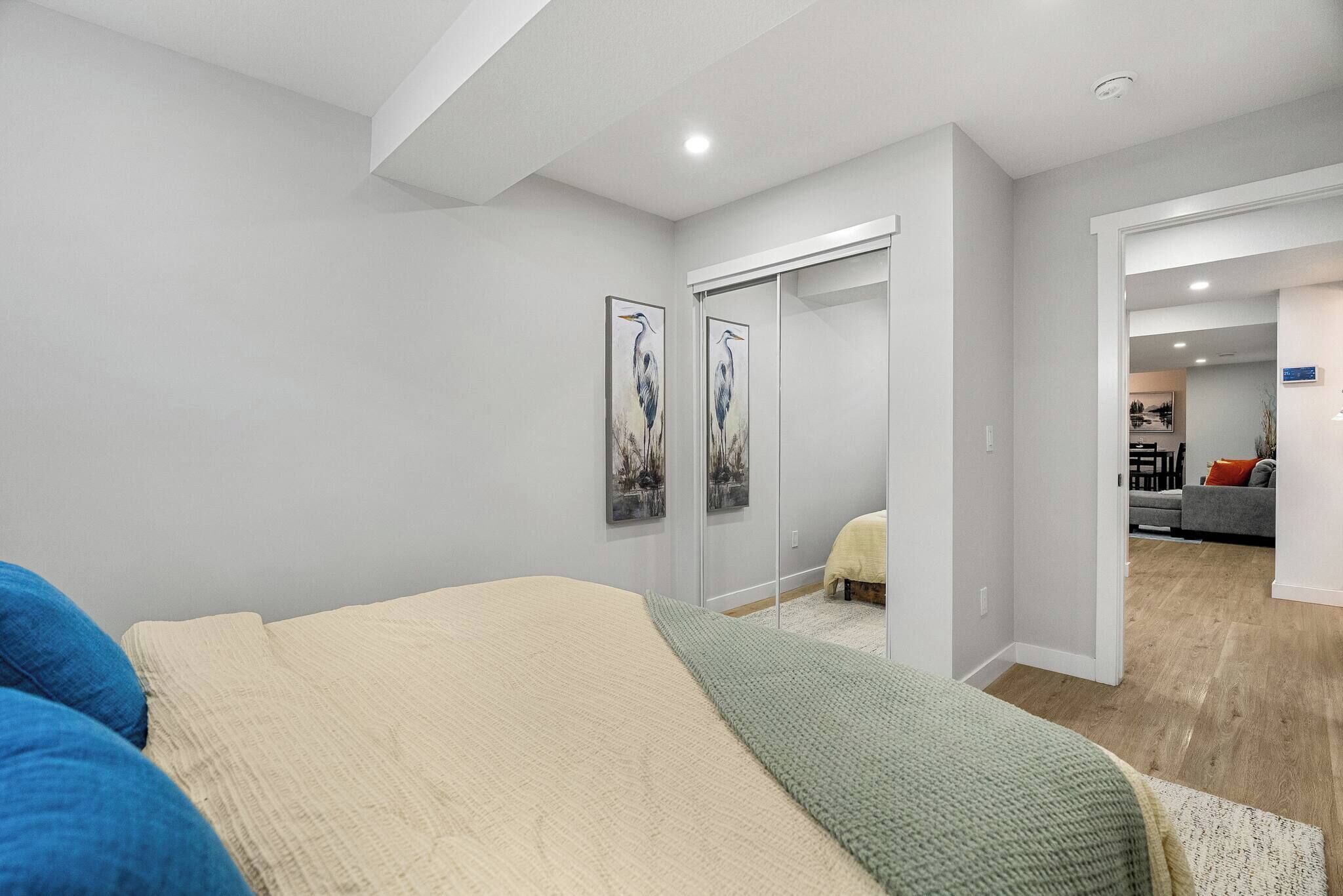 Un dormitorio moderno con cama, armario y vista al salón.
