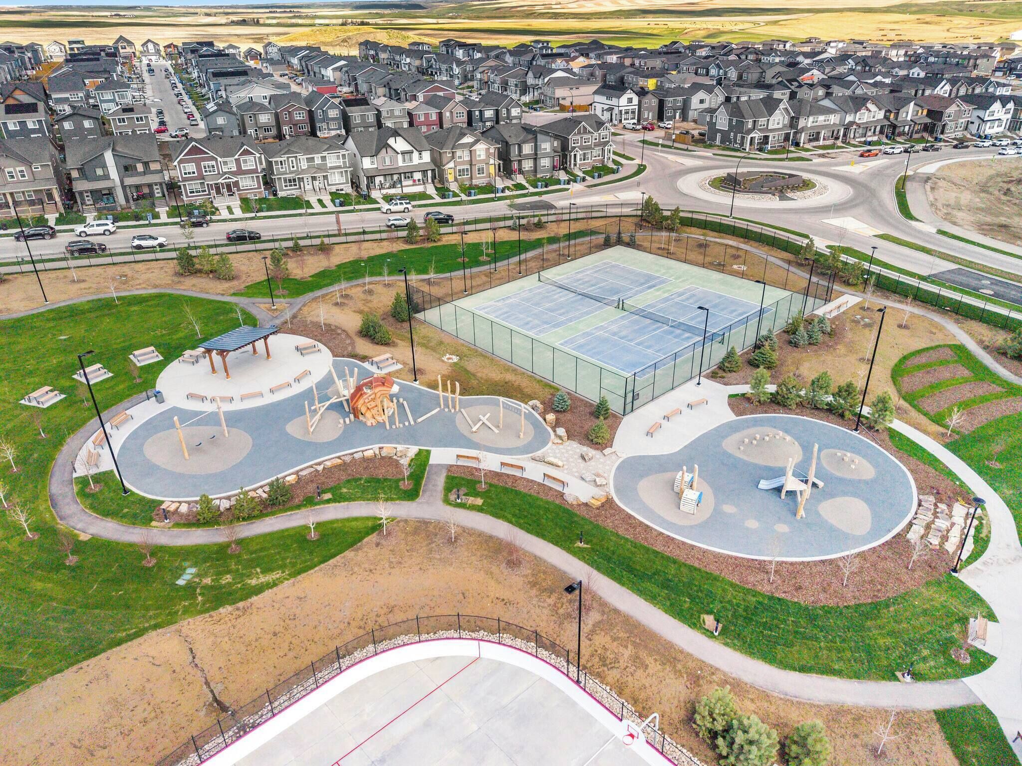 A residential area with a large sports court, playground, and a roundabout.