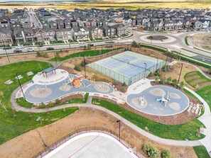 A residential area with a large sports court, playground, and a roundabout. - Latobir Modern,stylish 2BR Suite Private Entrance (Calgary)
