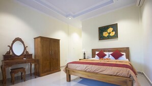 Un dormitorio con una cama, un armario de madera, un tocador y un espejo.