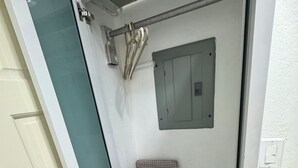 A narrow, enclosed space with a door, a small window, and a metal fixture on the wall. - Luxury house in soothing Spanish Town perfect for your getaway (Spanish Town)