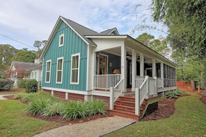 A two-story house with a porch, a front yard with landscaping, and a visible number '11' on the house.