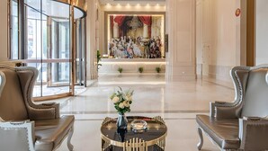 Eine geräumige Lobby mit einem prächtigen Kronleuchter, stilvoller Sitzgelegenheiten und einem großen Kunstwerk an der Wand.