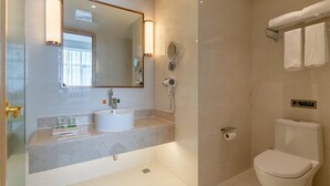 Ein Badezimmer mit Waschbecken, Spiegel, Handtuchhalter und Toilette.