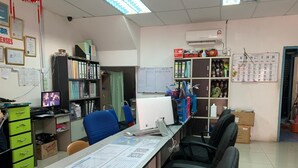 An office with a desk, computer, chairs, shelves with binders, and a calendar on the wall. - SBR Inn (Semporna)