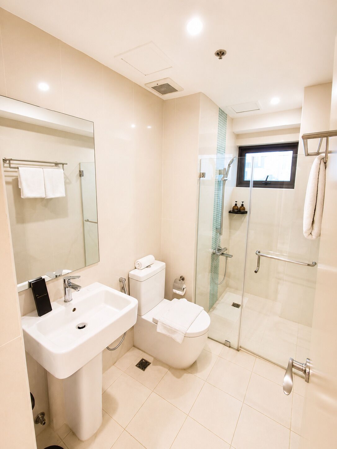A modern bathroom with a sink, toilet, and glass-enclosed shower.