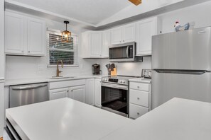 A modern kitchen with white cabinetry, stainless steel appliances, and a farmhouse-style pendant light. - Golden Splash, HotTub & Fire Pit, 15 Min2CVG (Florence)