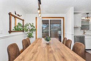 A dining room with a wooden table, chairs, a potted plant, and a hanging light fixture. - Golden Splash, HotTub & Fire Pit, 15 Min2CVG (Florence)