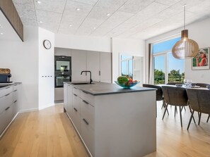 A modern kitchen with a large island, built-in appliances, and a dining area with a view. - "Hubertina" - 900m from the sea by Interhome (Ebeltoft)