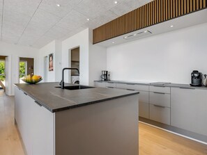 A modern kitchen with a central island, a built-in oven, and a coffee maker. - "Hubertina" - 900m from the sea by Interhome (Ebeltoft)