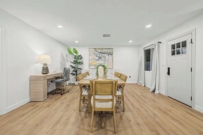 A dining area with a round table, chairs, a lamp, a potted plant, and a painting on the wall. - NEW Ocotillo Luxe Retreat Scottsdale Old Town (Scottsdale)