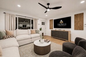 A modern living room with a sofa, coffee table, and TV. - NEW Ocotillo Luxe Retreat Scottsdale Old Town (Scottsdale)