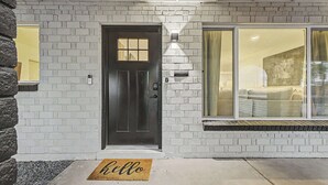 A house with a dark front door, white brick exterior, and a large window. - NEW Ocotillo Luxe Retreat Scottsdale Old Town (Scottsdale)