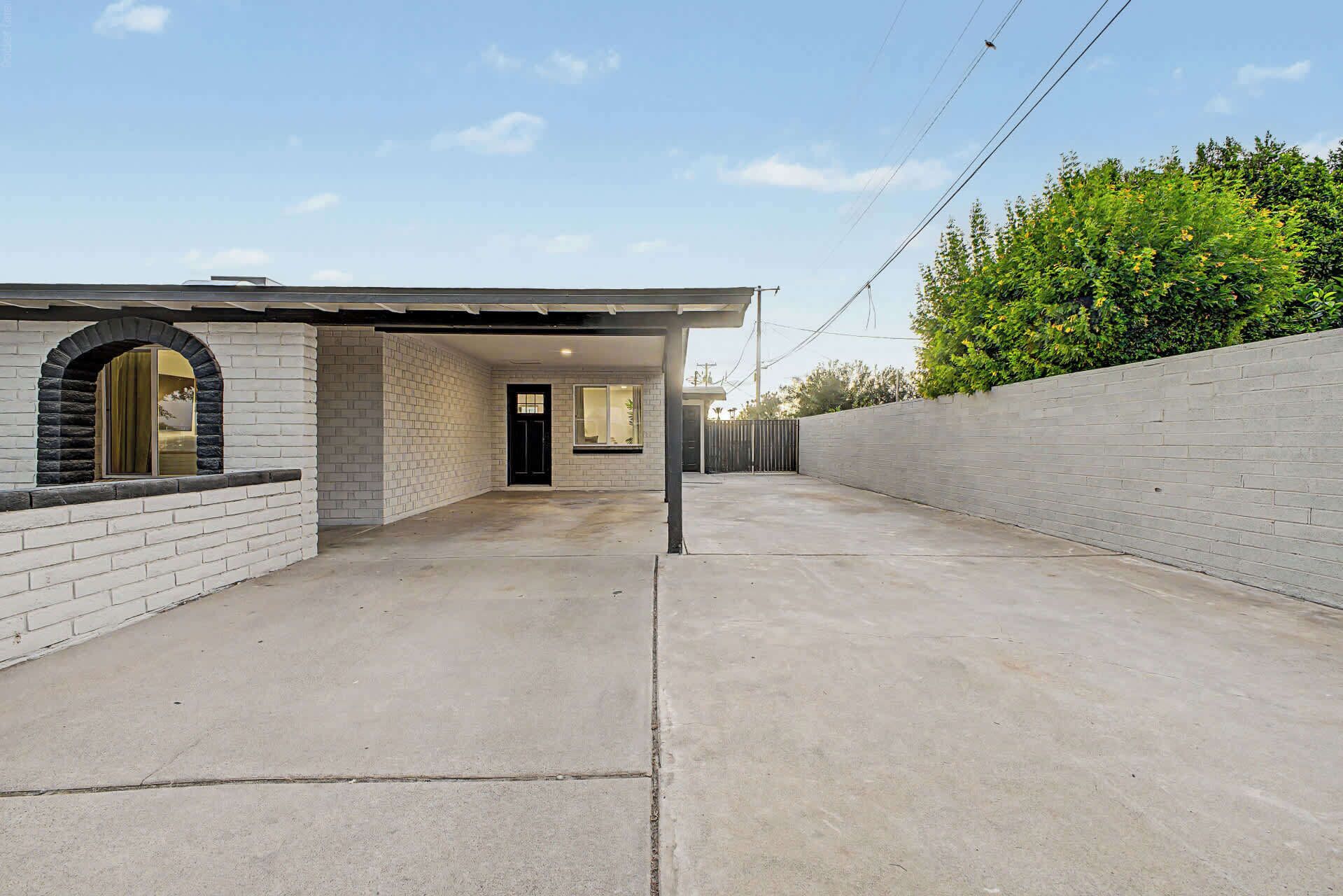 A residential property with a garage, a brick exterior, and a concrete driveway.