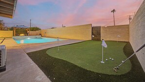 A backyard with a swimming pool, artificial turf, and a golf putting area. - NEW Ocotillo Luxe Retreat Scottsdale Old Town (Scottsdale)