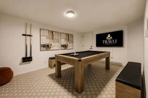 A pool table in a room with a patterned floor, a television mounted on the wall, and abstract artwork. - NEW Ocotillo Luxe Retreat Scottsdale Old Town (Scottsdale)
