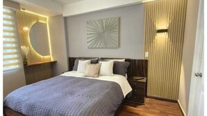 Un dormitorio moderno con una cama grande, una lámpara de pared y una lámpara del techo.