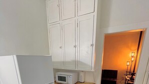 A compact kitchen with a refrigerator, microwave, and stove. - Historic Apt. Adjacent to Capitol/2 Queen Bds Loft Style near Medical/State Fair (Springfield)