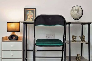 Ein Schreibtisch mit Globus, Lampe und gerahmtem Bild.